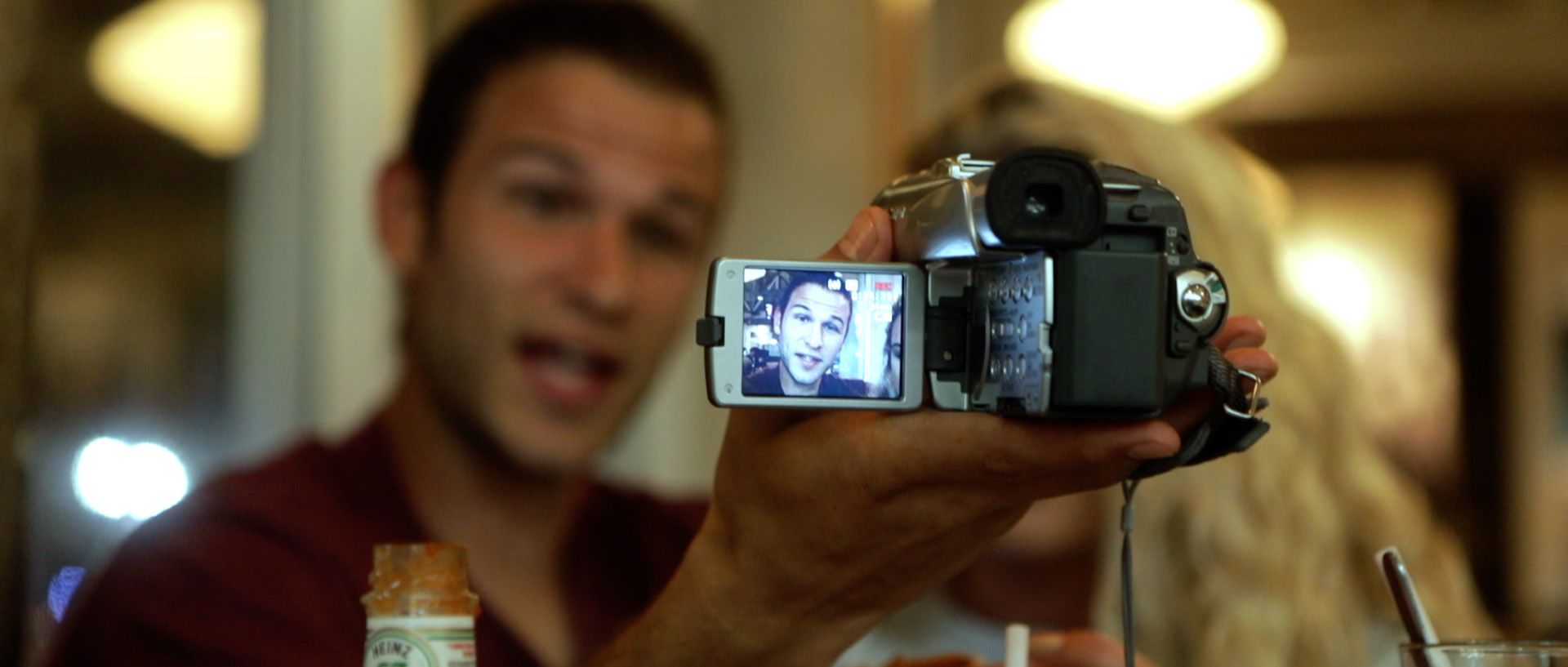 A still of JJ holding a video camera.